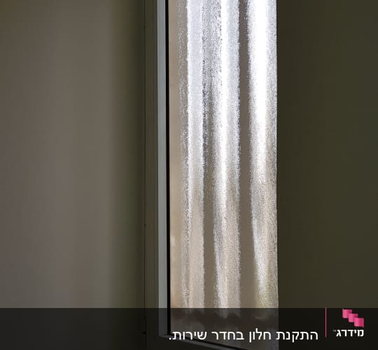 חלון עם מסגרת אלומיניום וקיר לבן
